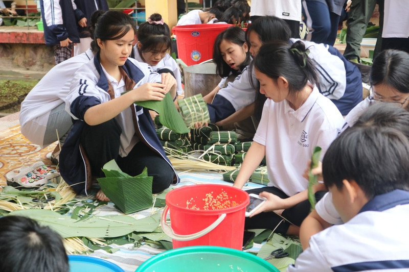 Một nữ sinh đang chăm chú bẻ lá dong để gói bánh. Một nữ sinh đang chăm chú bẻ lá dong để gói bánh.