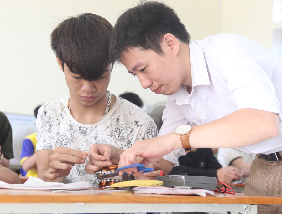 Thầy Thái Khắc Minh dạy học sinh quấn dây làm việc của quạt điện