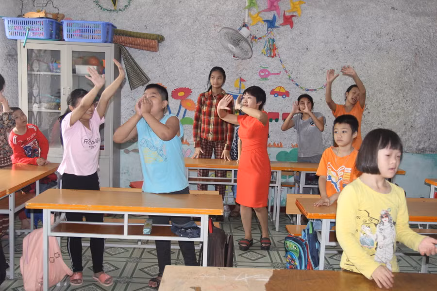 Cô giáo tập hát cho học sinh trong lớp học