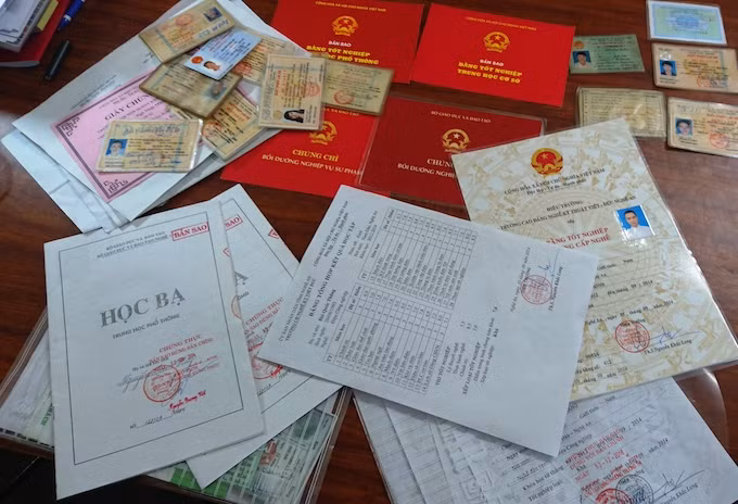 Nhiều loại giấy tờ giả trong đó có bằng tốt nghiệp CĐ bị cảnh sát thu giữ. Ảnh: Quang Hồng
