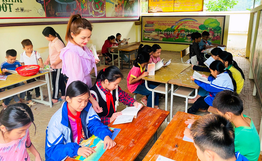 Cô giáo Hà My đang hướng dẫn học sinh đọc sách trong Thư viện xanh tại điểm trường chính - Trường Tiểu học Thanh Xuân.