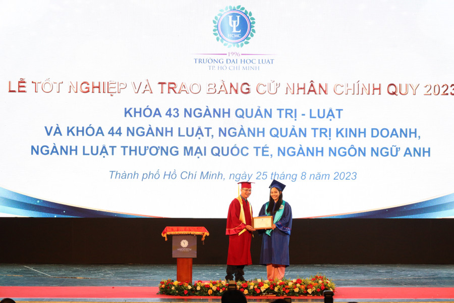 Tân cử nhân nhận bằng tốt nghiệp từ lãnh đạo nhà trường. Ảnh: HCMULAW.