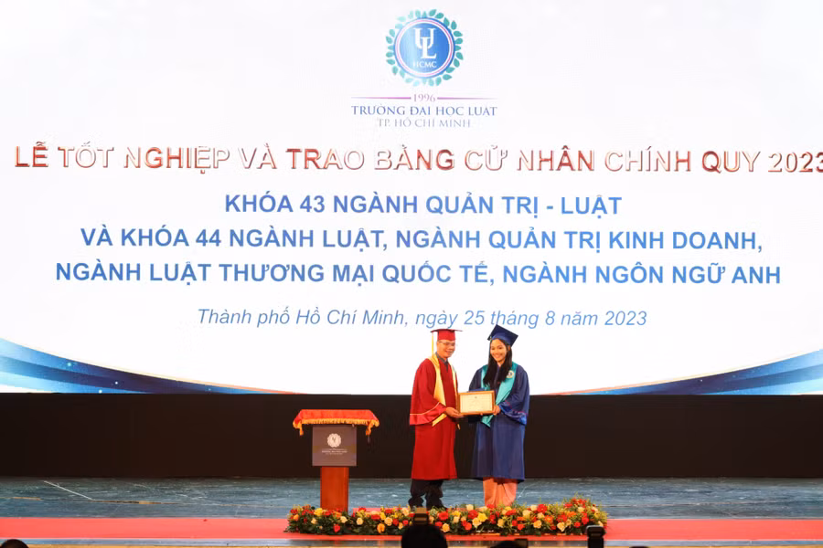 Tân cử nhân nhận bằng tốt nghiệp từ lãnh đạo nhà trường. Ảnh: HCMULAW.