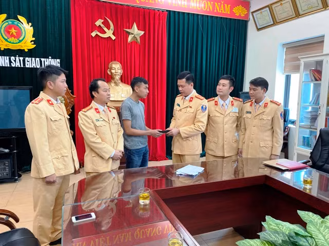 Phòng CSGT Công an Thanh Hóa trao lại chiếc ví tiền cho anh Hoàng Văn Nam.