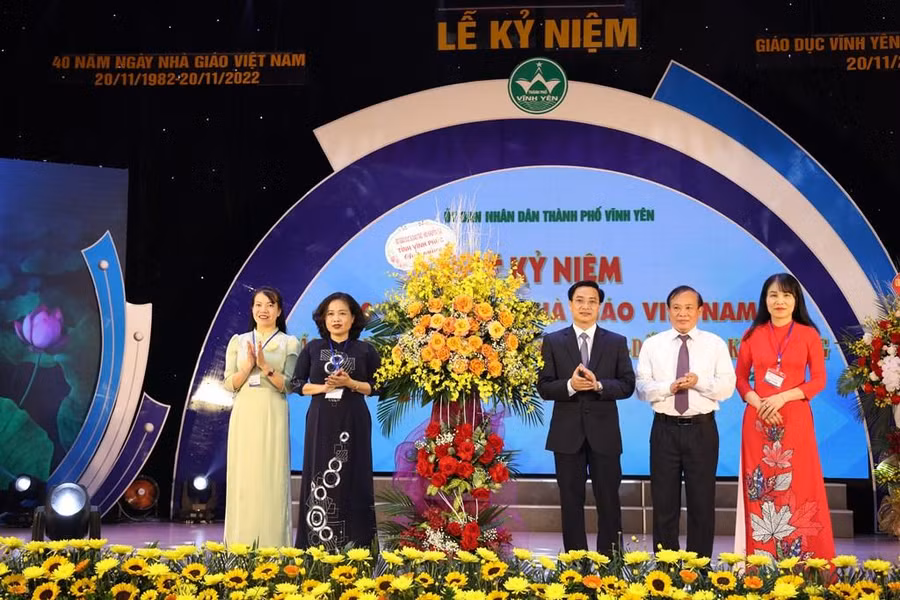 Giám đốc Sở GD&amp;ĐT Vĩnh Phúc Nguyễn Văn Huyến (thứ 3 từ phải qua) tặng hoa chúc mừng ngành GD&amp;ĐT thành phố Vĩnh Yên