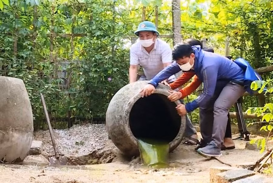 Lực lượng Y tế và người dân ở phường Hải Thanh (thị xã Nghi Sơn, Thanh Hóa) đổ kiệt nước đọng trong các chum để phòng dịch sốt xuất huyết.