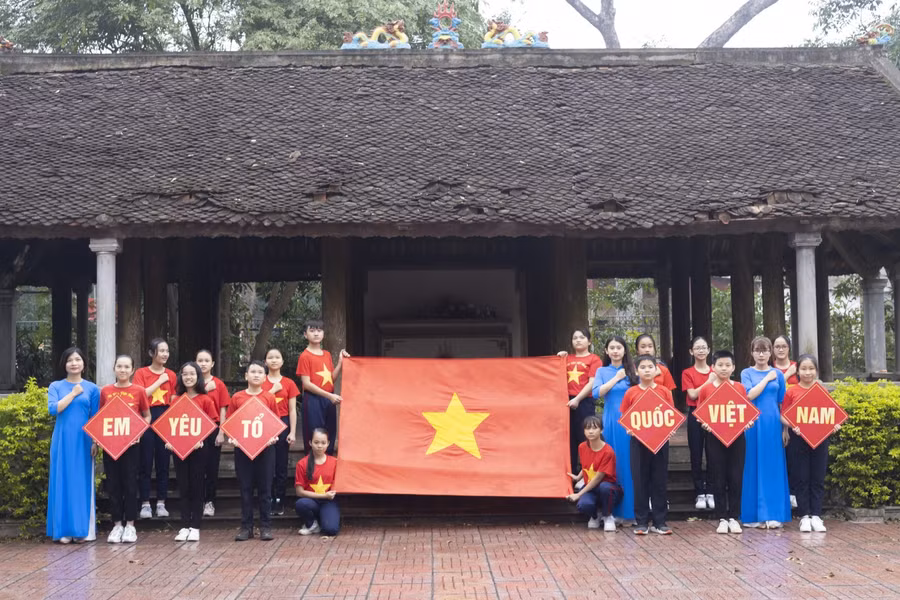 Học sinh và giáo viên hát quốc ca tại địa chỉ đỏ - Đình Làng Trung, phường Hưng Dũng, TP Vinh.