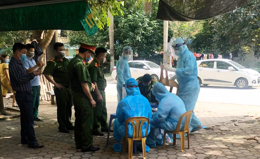 Lực lượng chức năng lấy mẫu xét nghiệm của những người ở gần nhà bệnh nhân Covid-19 tại Khu chung cư Đông Phát, phường Đông Vệ, TP Thanh Hóa.