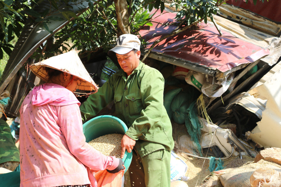 Người dân giúp gom lại lúa bị tràn ra cho chủ hàng. Ảnh: L. Phú Người dân giúp gom lại lúa bị tràn ra cho chủ hàng. Ảnh: L. Phú
