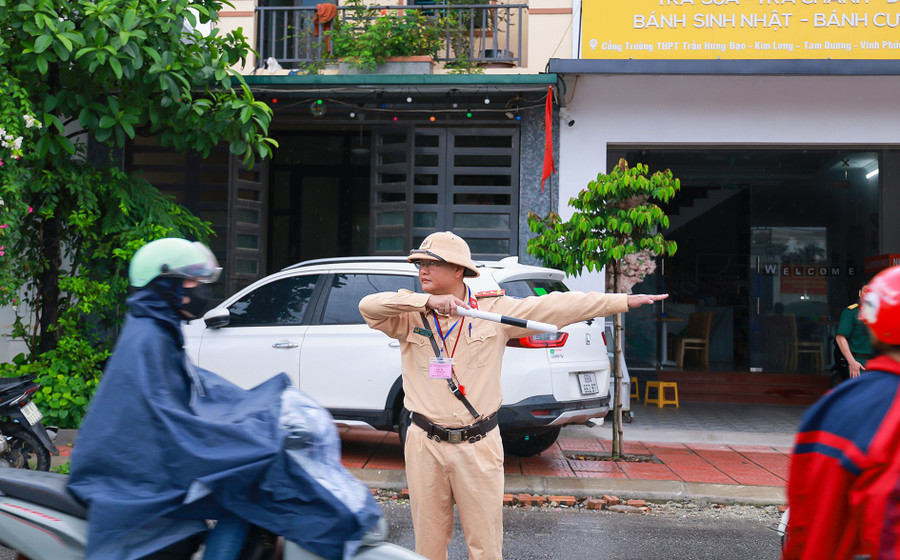 Dù mưa hay nắng, các chiến sĩ công an, bộ đội vẫn miệt mài làm nhiệm vụ, đảm bảo an toàn cho kỳ thi. Ảnh trước điểm thi Trường THPT Trần Hưng Đạo (Vĩnh Phúc).