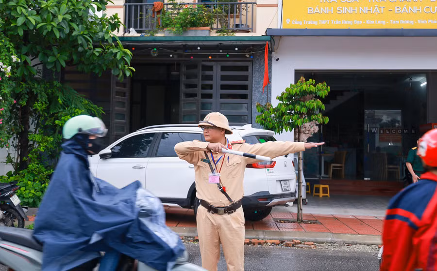 Dù mưa hay nắng, các chiến sĩ công an, bộ đội vẫn miệt mài làm nhiệm vụ, đảm bảo an toàn cho kỳ thi. Ảnh trước điểm thi Trường THPT Trần Hưng Đạo (Vĩnh Phúc).