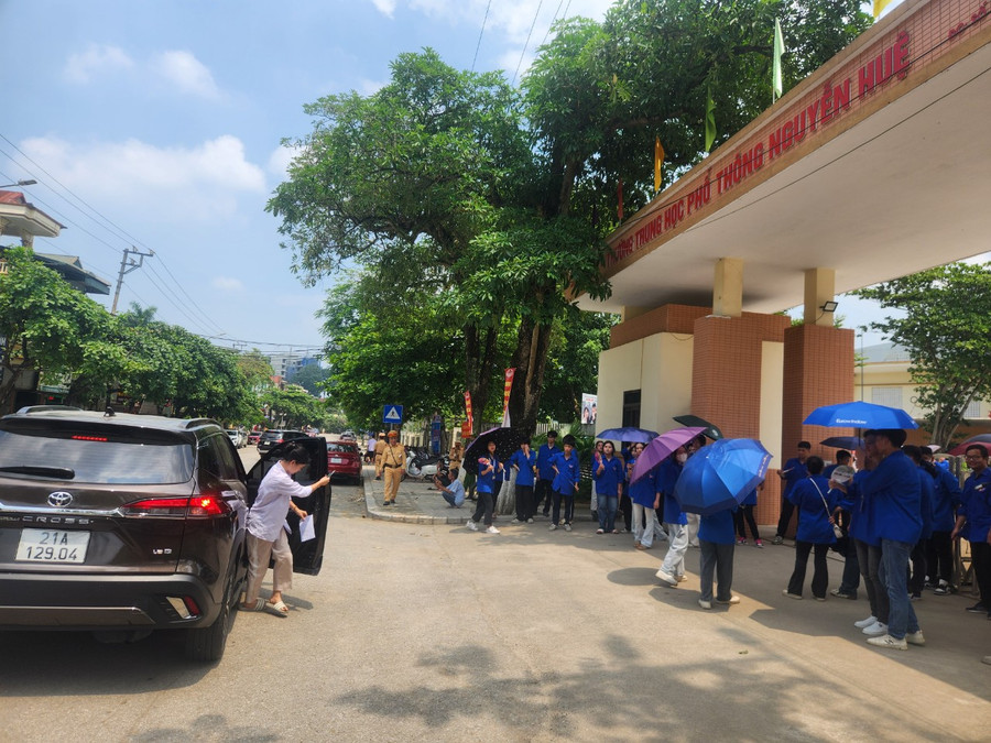 Thanh niên tình nguyện nhiệt tình che ô, động viên các thí sinh dưới tiết trời nắng gắt và oi bức.