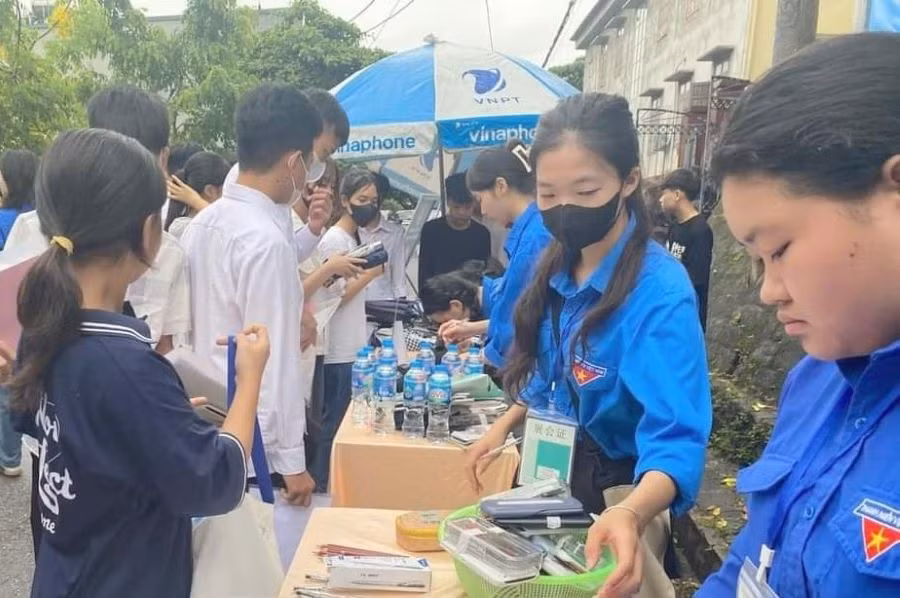 Các tình nguyện viên tiếp sức mùa thi tại Hội đồng thi Trường THPT Phong Châu (huyện Lâm Thao) nhiệt tình hỗ trợ thí sinh