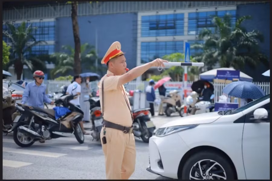 Đại úy Phan Văn Tuyến phân luồng giao thông tại điểm thi Trường THPT Chuyên Vĩnh Phúc.