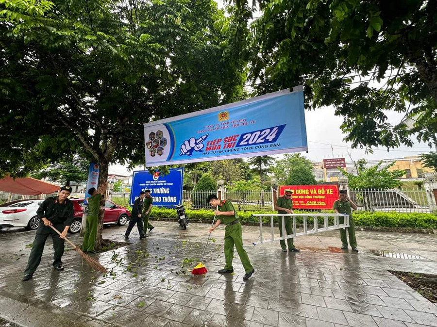 Cán bộ, chiến sĩ công an thị xã Nghĩa Lộ (Yên Bái), quét dọn trước điểm thi sau trận mưa lớn.