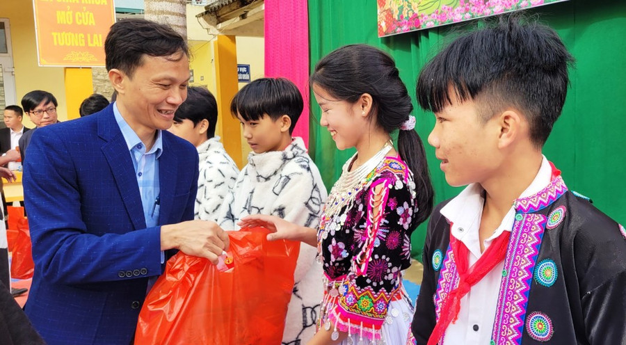 Thầy giáo Nguyễn Duy Thủy – Hiệu trưởng Trường PTDTBT- THCS Trung Lý trao quà cho học sinh nghèo. Ảnh: TL