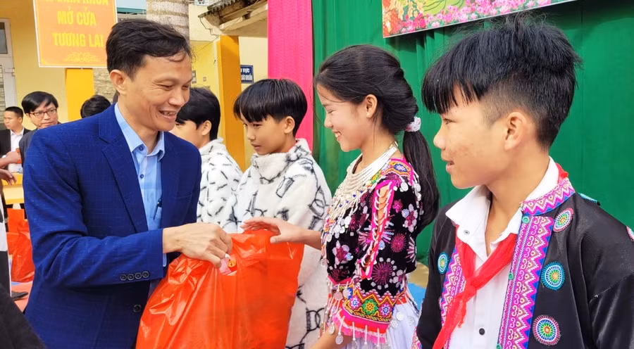 Thầy giáo Nguyễn Duy Thủy – Hiệu trưởng Trường PTDTBT- THCS Trung Lý trao quà cho học sinh nghèo. Ảnh: TL