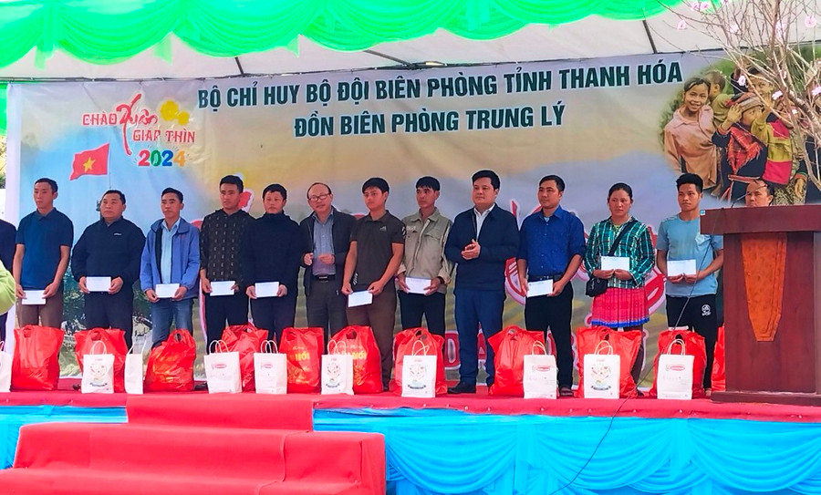 Nhà báo Hà Đồng - Phóng viên thường trú Báo Tuổi trẻ TP Hồ Chí Minh tại Thanh Hóa (người đeo kính) trao quà cho người dân xã Trung Lý tại Đồn Biên phòng Trung Lý. Ảnh: TL