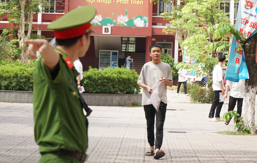 Cán bộ công an hướng dẫn thí sinh ra ngoài sau khi xong tại điểm thi Trường THPT Huỳnh Thúc Kháng. Ảnh: Hồ Lài. Cán bộ công an hướng dẫn thí sinh ra ngoài sau khi xong tại điểm thi Trường THPT Huỳnh Thúc Kháng. Ảnh: Hồ Lài.