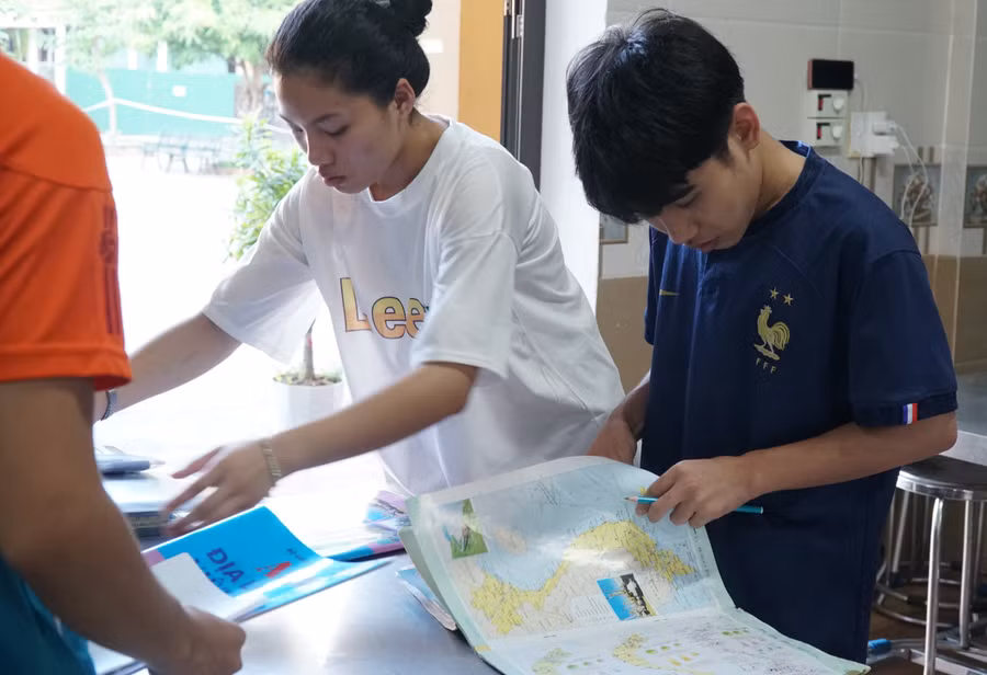 Thí sinh kiểm tra Atlat Địa lý của mình, đảm bảo không viết tay hoặc có ký hiệu riêng trước khi đưa vào phòng thi. Ảnh: Hồ Lài. Thí sinh kiểm tra Atlat Địa lý của mình, đảm bảo không viết tay hoặc có ký hiệu riêng trước khi đưa vào phòng thi. Ảnh: Hồ Lài.