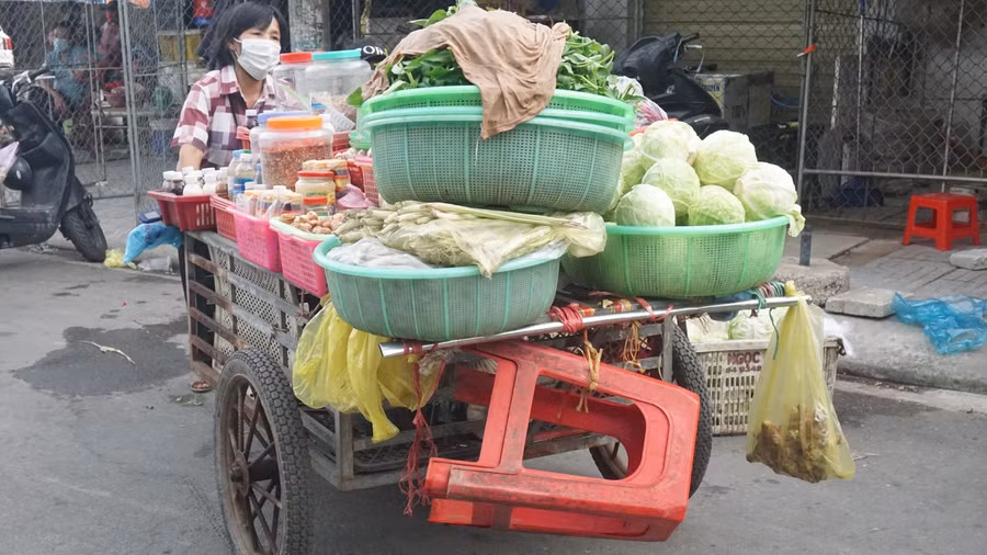 Những xe hàng chất hàng hóa cao quá đầu người được tiểu thương hối hả đẩy ra khỏi chợ