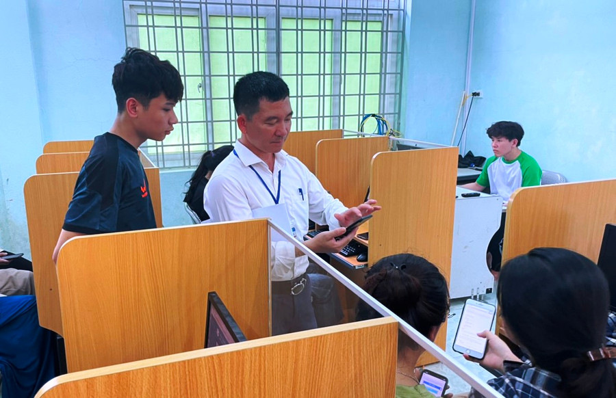 Thầy giáo Trường THPT Quan Sơn hướng dẫn học sinh ĐKDT tốt nghiệp trên thiết bị điện thoại thông minh. Ảnh: TL. Thầy giáo Trường THPT Quan Sơn hướng dẫn học sinh ĐKDT tốt nghiệp trên thiết bị điện thoại thông minh. Ảnh: TL.