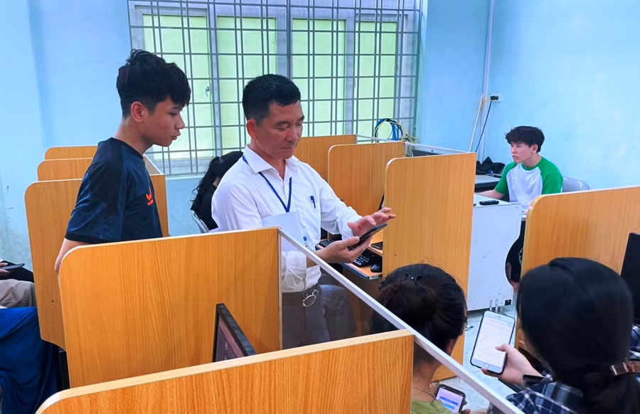 Thầy giáo Trường THPT Quan Sơn hướng dẫn học sinh ĐKDT tốt nghiệp trên thiết bị điện thoại thông minh. Ảnh: TL.