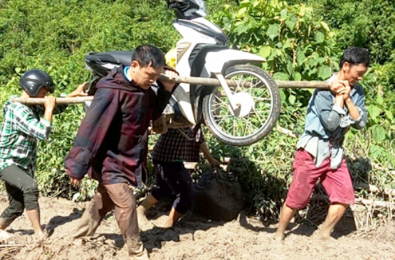 Thầy giáo Lang Văn Long và người dân khiêng xe máy để đến điểm trường ở thời điểm bị mưa lũ năm 2018. Ảnh: NVCC. Thầy giáo Lang Văn Long và người dân khiêng xe máy để đến điểm trường ở thời điểm bị mưa lũ năm 2018. Ảnh: NVCC.