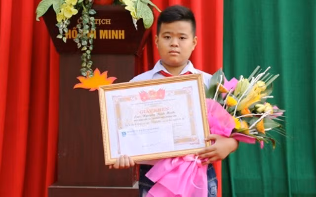 Em Nguyễn Bình Minh, học sinh lớp 7A, Trường THCS Đông Tân, TP.Thanh Hóa đón nhận giấy khen của Chủ tịch UBND TP.Thanh Hóa.