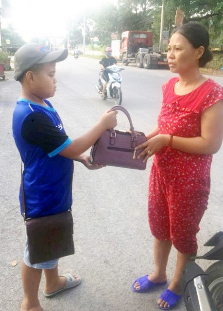 Em Nguyễn Bình Minh trao trả chiếc túi xách cho chị Lê Thị Oanh. Em Nguyễn Bình Minh trao trả chiếc túi xách cho chị Lê Thị Oanh.