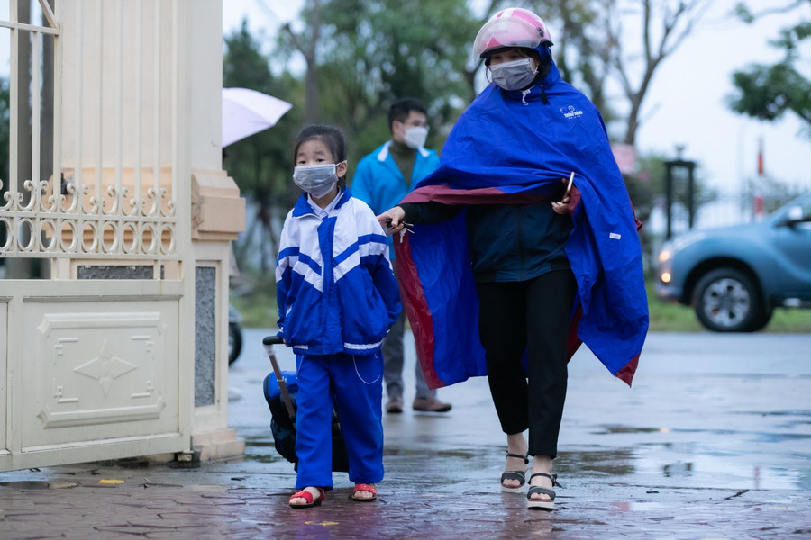 Buổi học đầu tiên thời tiết mưa rét nhưng các bạn học sinh tiểu học vẫn dậy sớm, được bố mẹ đưa đến trường đúng giờ.