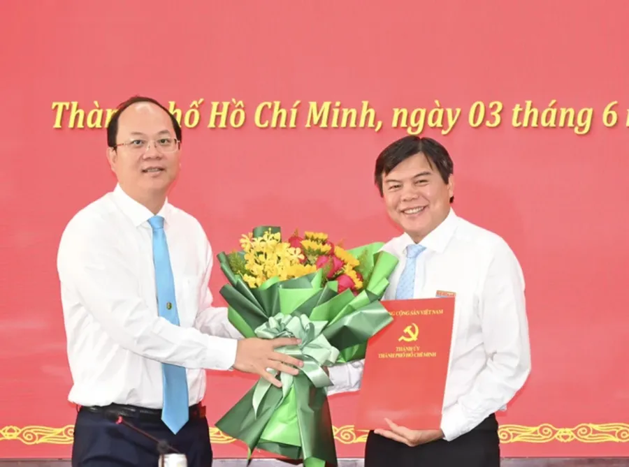 Phó Bí thư Thường trực Thành ủy TPHCM Nguyễn Hồ Hải (trái) trao quyết định của Ban Thường vụ Thành ủy TPHCM cho ông Tăng Hữu Phong. (Ảnh: SGGP)