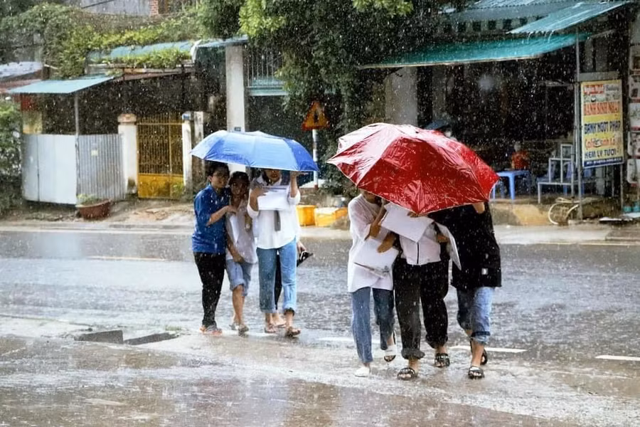 Thí sinh ở Thanh Hóa đội mưa đến trường để dự thi môn Toán.