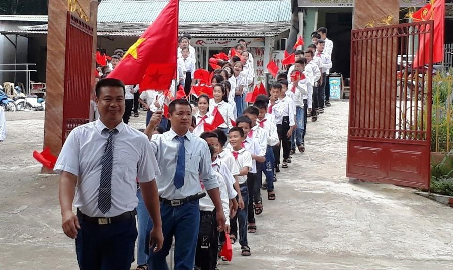 Thầy giáo đón học sinh vào lớp 6 ở Trường Phổ thông dân tộc bán trú THCS Sơn Điện, huyện Quan Sơn (Thanh Hóa)