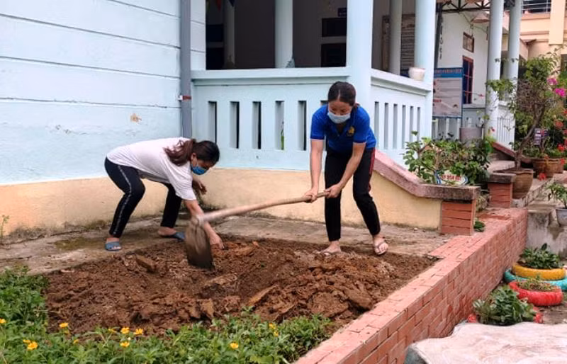 Cô giáo Trường Mầm non thị trấn Sơn Lư (Quan Sơn, Thanh Hóa) xáo đất để trồng hoa tại trường.