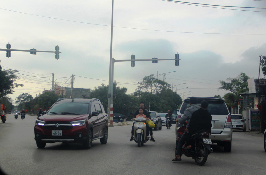 Chở con nhỏ phía trước cũng không mũ bảo hiểm.