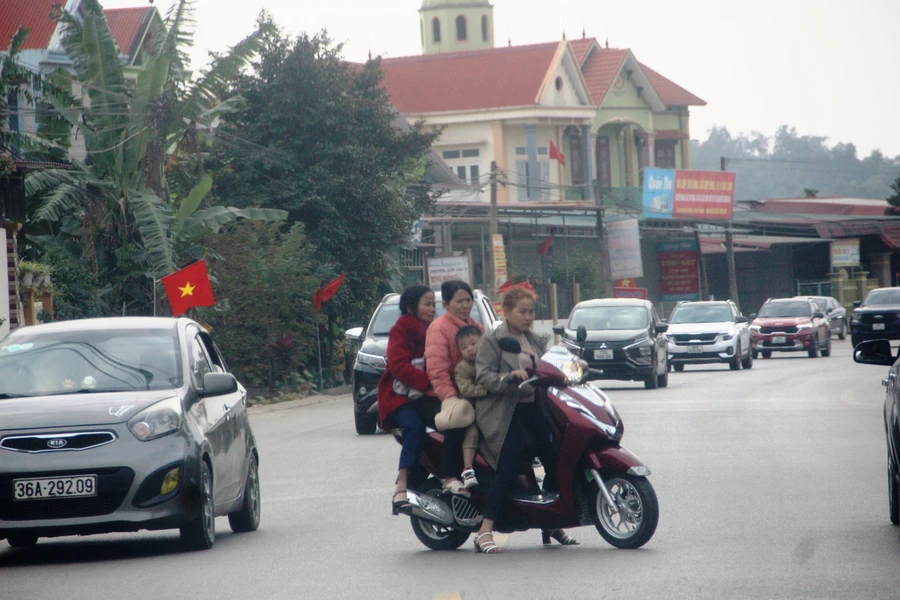 Một phụ nữ đi xe máy chở bốn người trên Quốc lộ 47, nhưng đều không đội mũ bảo hiểm.