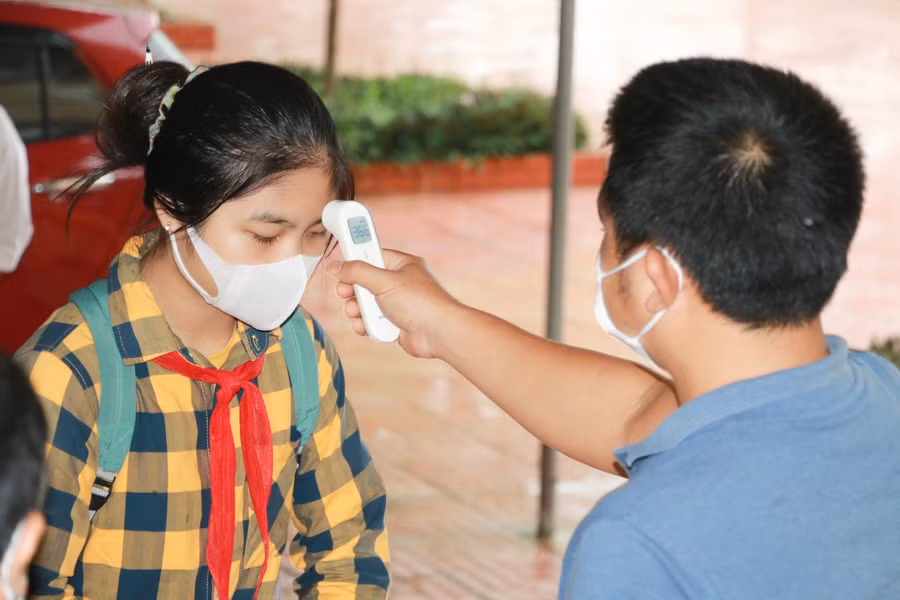 Đo thân nhiệt cho học sinh trường khi vào lớp tại Trường THCS Tôn Quang Phiệt (huyện Thanh Chương, Nghệ An).