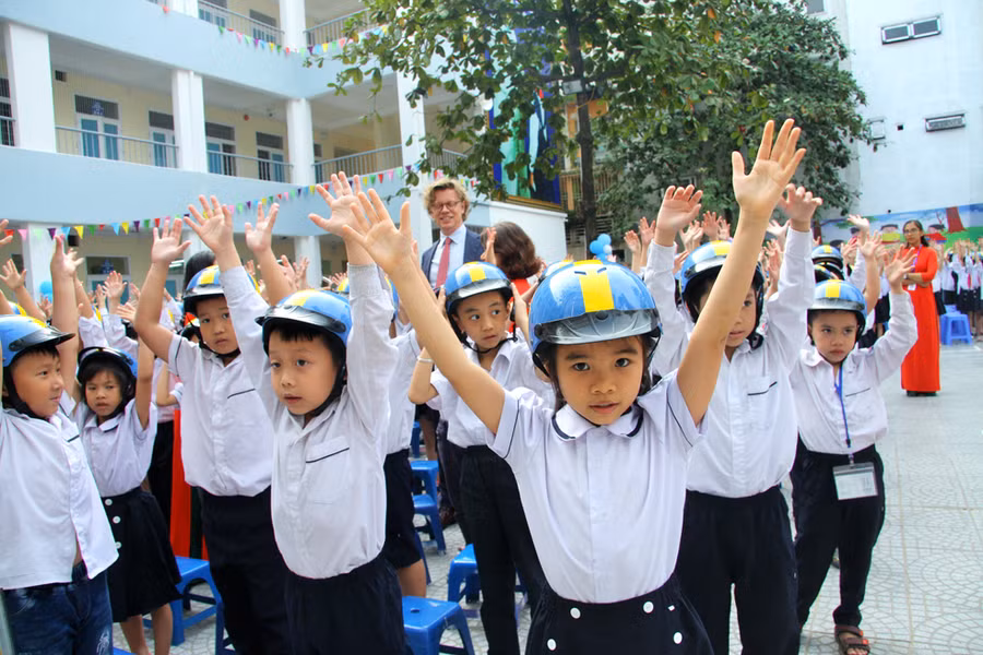 Học sinh cùng các thầy cô,đại diện phụ huynh, Đại sứ Thụy Điển... nhảy đồng diễn toàn trường bài "Em yêu chiếc mũ bảo hiểm"