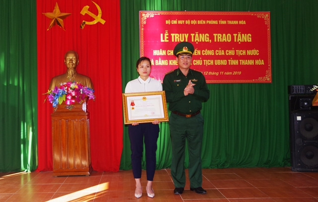 Chị Lương Thị Chon- vợ của liệt sĩ Vi Văn Nhất đón nhận Huân chương chiến công hạng Nhất do Chủ tịch nước truy tặng.