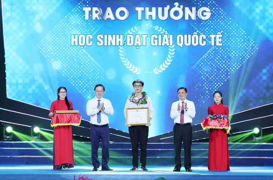 Bí thư tỉnh ủy Nghệ An ông Thái Thanh Quý và Chủ tịch UBND tỉnh ông Nguyễn Đức Trung tặng bằng khen cho em Mai Văn Đức đạt Huy chương Bạc Olympic Hóa học quốc tế. Ảnh: Hồ Lài