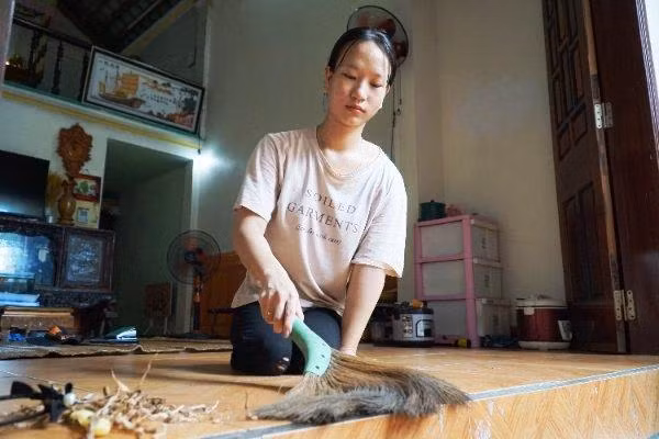 Nữ sinh Nguyễn Thị Thùy quét tước nhà cửa giúp mẹ.