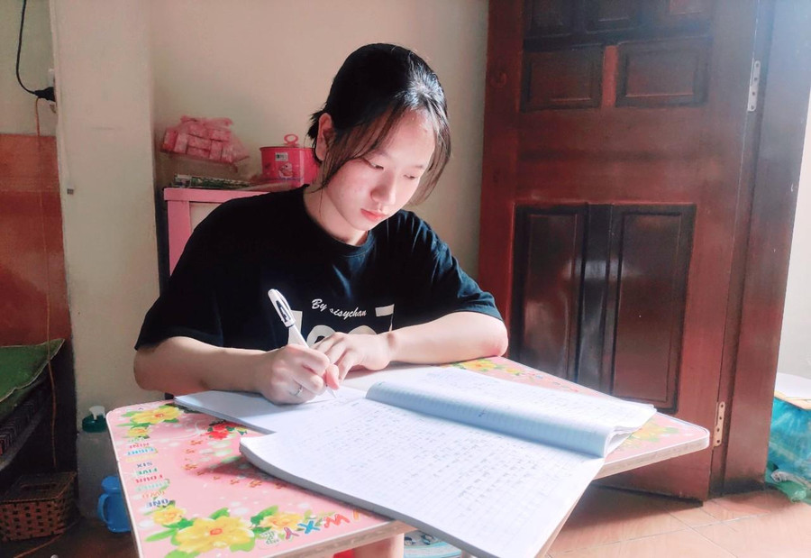 Nữ sinh Nguyễn Thị Thùy bên bàn học của mình tại gia đình.