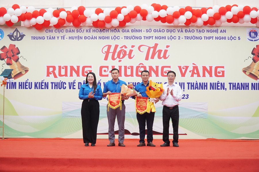 Đại diện Tỉnh đoàn và Chi cục Dân số - Kế hoạch hóa gia đình tỉnh Nghệ An trao cờ lưu niệm cho 2 đơn vị Trường THPT Nghi Lộc 2, THPT Nghi Lộc 5 tham gia hội thi. Ảnh: Hồ Lài.