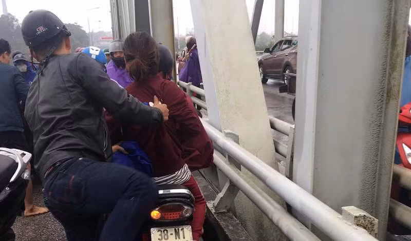 Người dân hỗ trợ đưa cô gái về nhà sau khi được cứu từ dưới sông lên