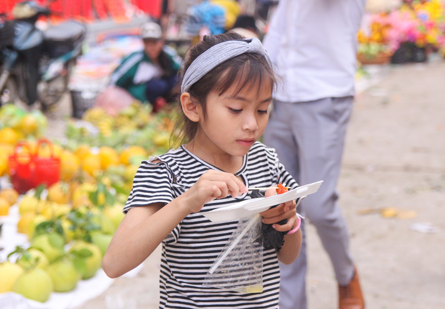 Một bé gái khác thì say sưa với món xúc xích khoái khẩu