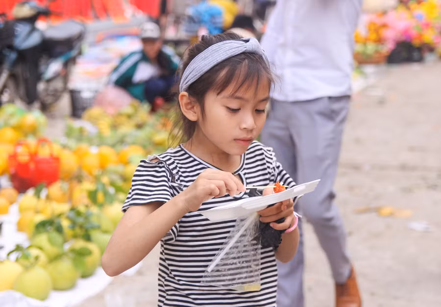 Một bé gái khác thì say sưa với món xúc xích khoái khẩu