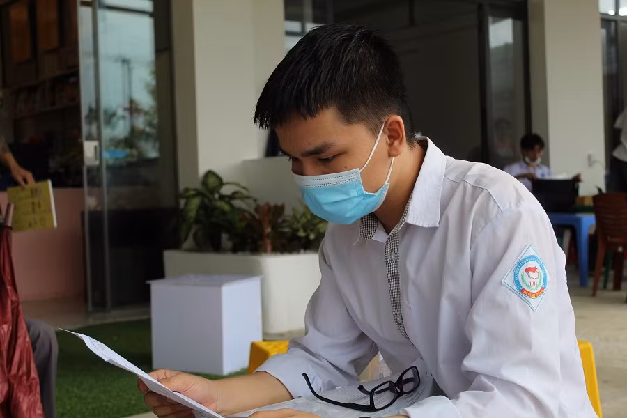 Thí sinh Hoàng Văn Thảo xem lại đề thi môn Toán sau khi rời phòng thi.