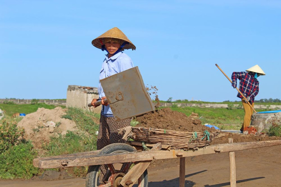 Công đoạn làm cát phơi trên nền đất, để sản xuất muối.