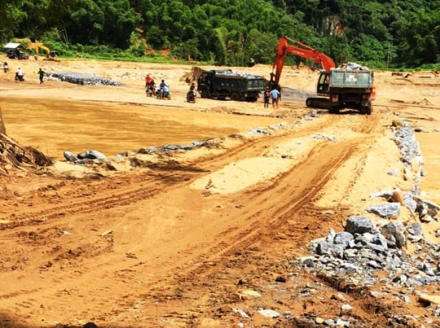 Tạo thành mặt đường cho xe chở vật liệu vượt sông Luồng vào bản Sa Ná.